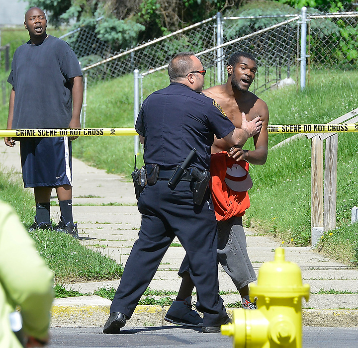 Third Place, Photographer of the Year - Small Market - Bill Lackey / Springfield News-SunA member of the Springfield Police Division tries to calm down a visibly upset man as he tries to rush into a crime scene at the intersection of South Lowry and Grand Avenues where George Walker, a well known football standout at Springfield High School, was shot and killed in a drive-by shooting. 