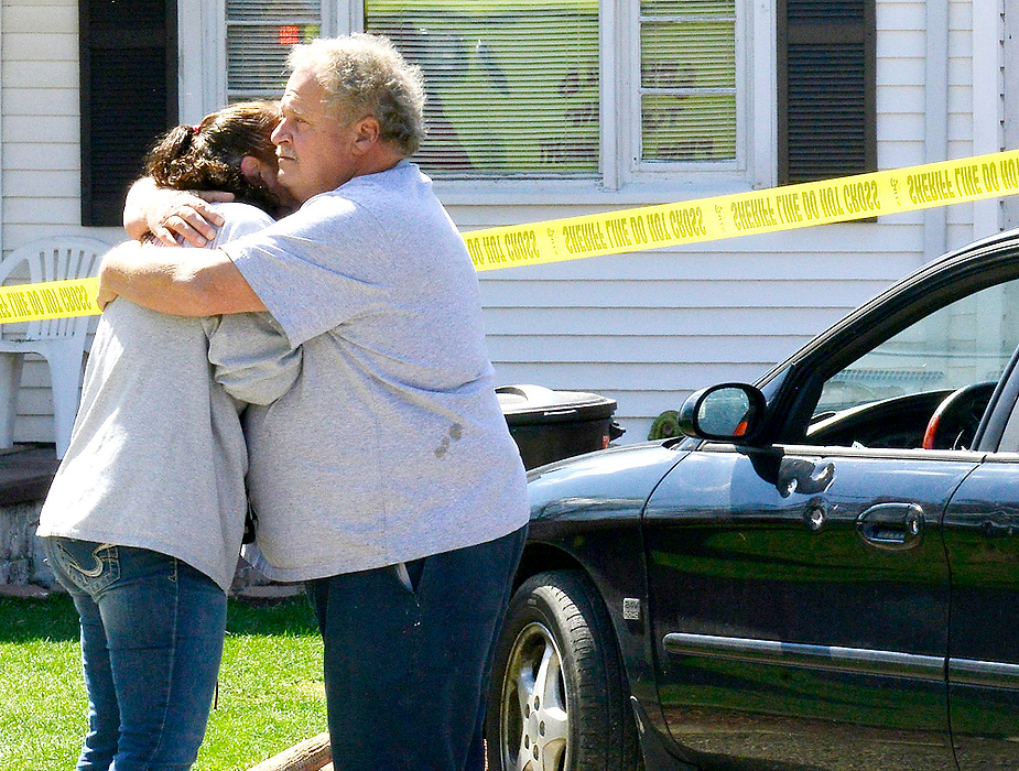 Third Place, Photographer of the Year - Small Market - Bill Lackey / Springfield News-SunFamily members console each other next to a bullet riddled car along Alta Road in Springfield Township. According to the Clark County Sheriff, the 22-year-old male driver was shot during an apparent drug deal on Pumphouse Road and drove to Alta Road where he crashed his car. 