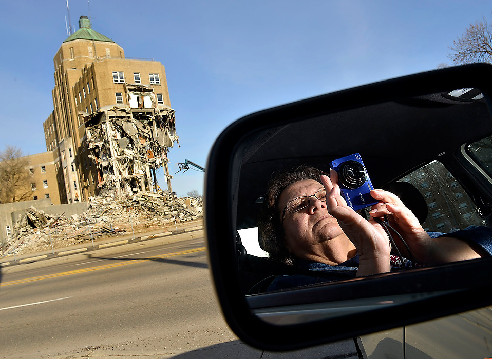 Third Place, Photographer of the Year - Small Market - Bill Lackey / Springfield News-SunPam Wallace, of Tremont City, is reflected in the sideview mirror of her car as she takes pictures of the Community Hospital demolition. Wallace was just one of several people who sat in their cars in a parking lot across the street to watch as the city's original hospital was torn down. 
