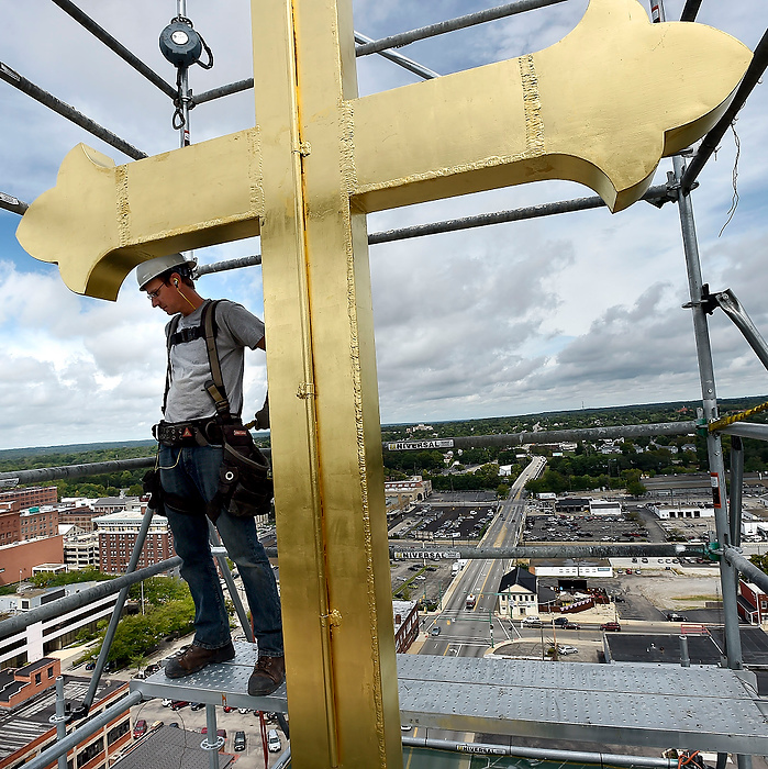 Third Place, Photographer of the Year - Small Market - Bill Lackey / Springfield News-SunMichael Ranvall, an employee of Millennium Preservation Group, Inc. looks down at the ground 180 feet below after the new 10 foot cross was attached to the top of the St. Raphael Catholic Church steeple. The gold cross was raised into place following a blessing ceremony. The 130-year-old church has recently undergone a major renovation. 