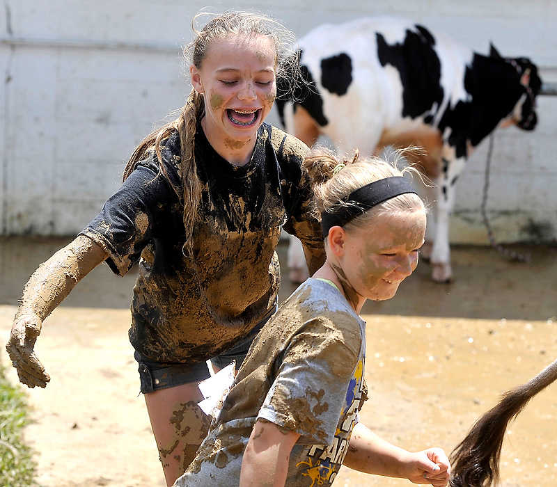 Third Place, Photographer of the Year - Small Market - Bill Lackey / Springfield News-SunMorgan Waymire, 13, (left) and Kendall Spencer, 11, splash mud on each other after cleaning their calf at the fair. 
