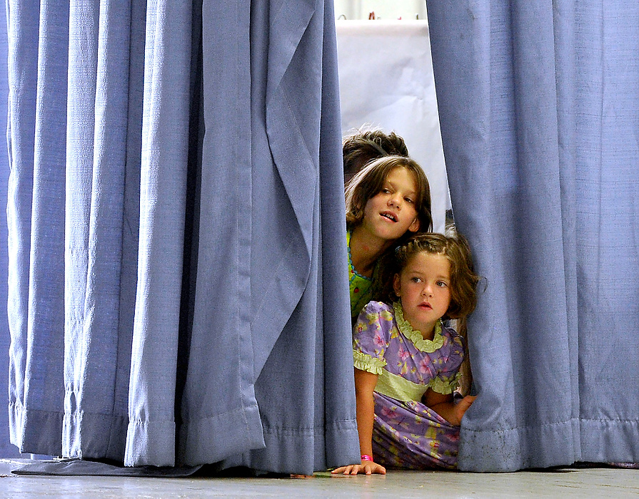 Third Place, Photographer of the Year - Small Market - Bill Lackey / Springfield News-SunMary Ellen Moore and Aubrey Moore peek through the curtain as they watch a fellow model walk on the catwalk Thursday during the Homemakers Style Show at the fair.