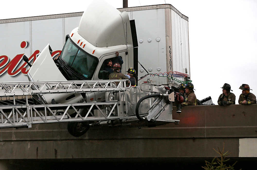 Second Place, Spot News - Large Market - Eamon Queeney / The Columbus DispatchA truck driver is pulled out of cab by Columbus firefighters as it dangles on the edge of the 315 north-bound bridge over Sullivant Avenue in Columbus. The north-bound lanes of 315 had to be closed as emergency responders worked to save the driver of a crashed semi trailer. 