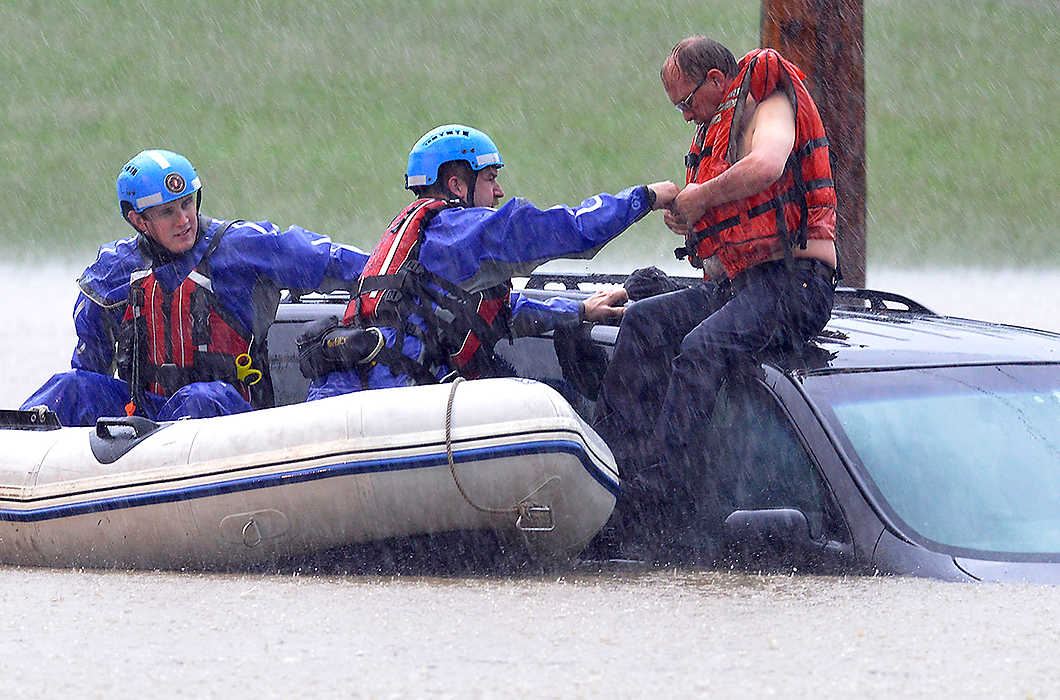 Third Place, Spot News - Small Market - Bill Lackey / Springfield News-SunMembers of the Huber Heights Water Recovery Team rescue a stranded motorist from the roof of his car after it became submerged in several feet of water during a storm. The motorist drove around a fire engine blocking the intersection of Gerlaugh Road and Ohio 235 and became stranded. 