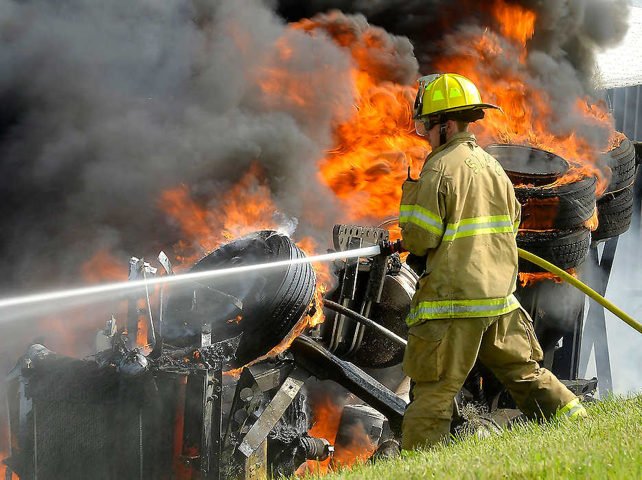 Award of Excellence, Spot News - Small Market - Bill Lackey / Springfield News-SunFlames engulf a tractor trailer rig on west bound I-70 between State Route 41 and US 40 as members of the Springfield and Harmony Township fire departments battled the flames. The semi rolled over and burst into flames after striking another semi that was parked along shoulder of the highway. The driver of the burning semi escaped without injuries. 