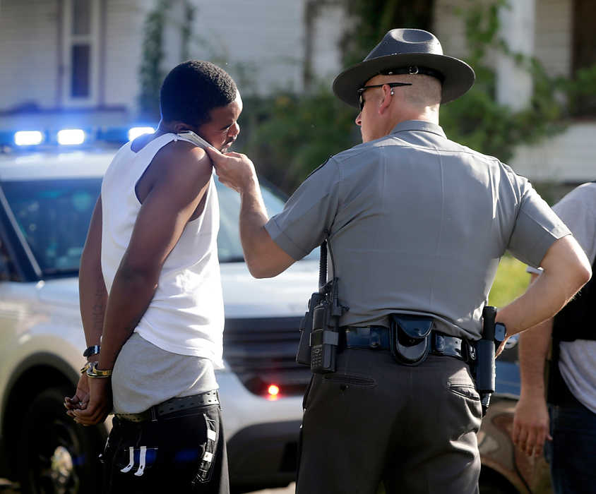 Award of Excellence, Spot News - Small Market - Scott Heckel / The (Canton) RepositoryDeante Walker was arrested and put in handcuffs on felony heroine, cocaine, and marijuana possession charges. Meanwhile Sgt. Jeff Greene of the State Highway Patrol holds Walker's cell phone as he explains what happened to his girlfriend whose car he was driving when authorities pulled him over. 