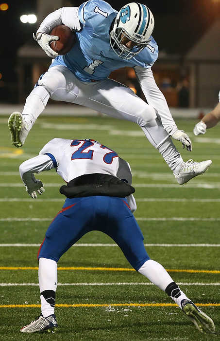 Award of Excellence, Sports Action - Thomas Ondrey Thomas Ondrey / The Plain DealerBenedictine's Dontez Rash hurdles Bay's Joe DeBarr to pick up a few more yards in a Div IV regional final game at Byers Field.