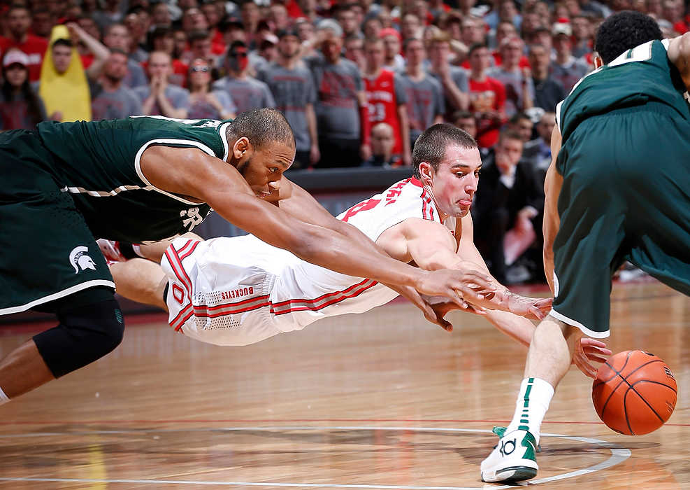 First Place, Ron Kuntz Sports Photographer of the Year - Eamon Queeney / The Columbus DispatchMichigan State guard Travis Trice (20) grabs the ball as Ohio State guard Aaron Craft (4) tries to dive for it in the second half at Value City Arena in Columbus. 