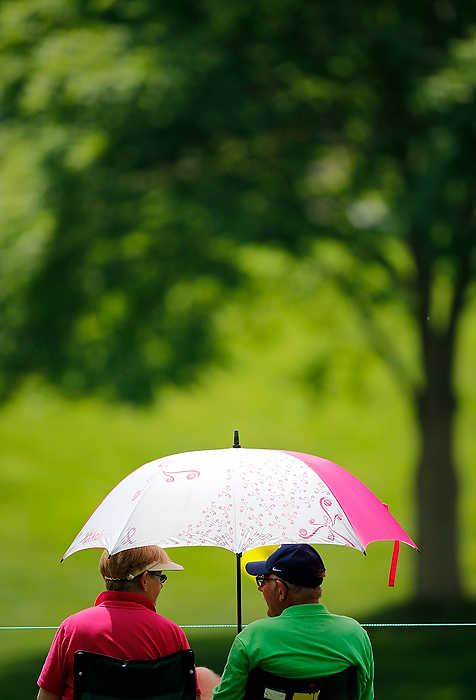 First Place, Ron Kuntz Sports Photographer of the Year - Eamon Queeney / The Columbus DispatchFirst time Memorial goers, Robin Hinkley (left) of Vienna, WV., and her husband Sheldon (right) share a moment under their umbrella as they sit in the sun on the sixth green during the Memorial Tournament's Nationwide Invitational Pro-am at Muirfield Village Golf Club in Dublin. 