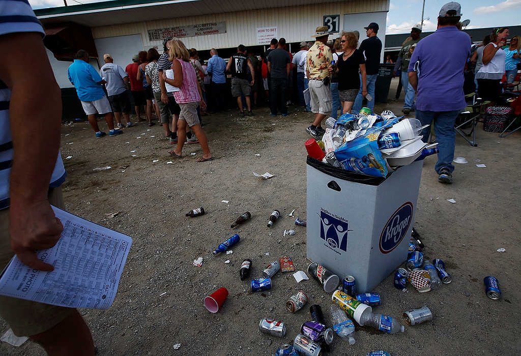 First Place, Ron Kuntz Sports Photographer of the Year - Eamon Queeney / The Columbus DispatchA trashcan overflows with empty beer cans and bottles as race goers line up to place bets during the 69th running of the Little Brown Jug at the Delaware County Fairgrounds.