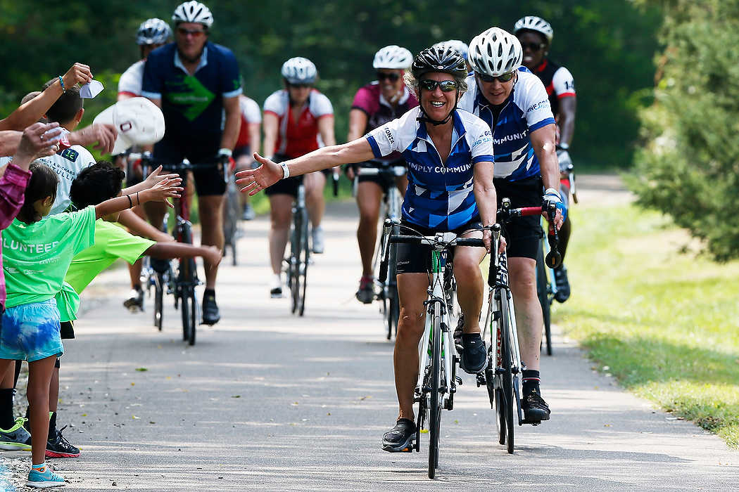 Third Place, Ron Kuntz Sports Photographer of the Year - Logan Riely / Ohio UniversityA ride high fives kids along the final stretch  of pavement towards the 100 mile finish line outside of the athletic center at Kenyon College during the 6th annual Pelotonia. 