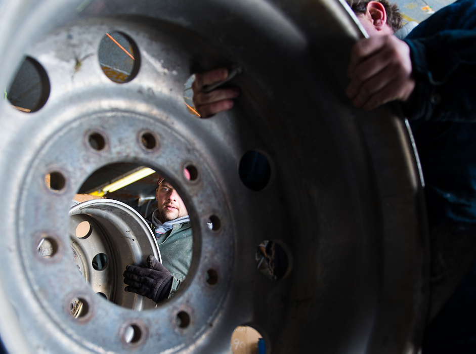 Second Place, Student Photographer of the year - Isaac Hale / Ohio UniversityStephen "EJ" Nichols, center, and Brian Kinnison move semi-truck rims into a bin at Cullison Scrap Metal outside of Athens.