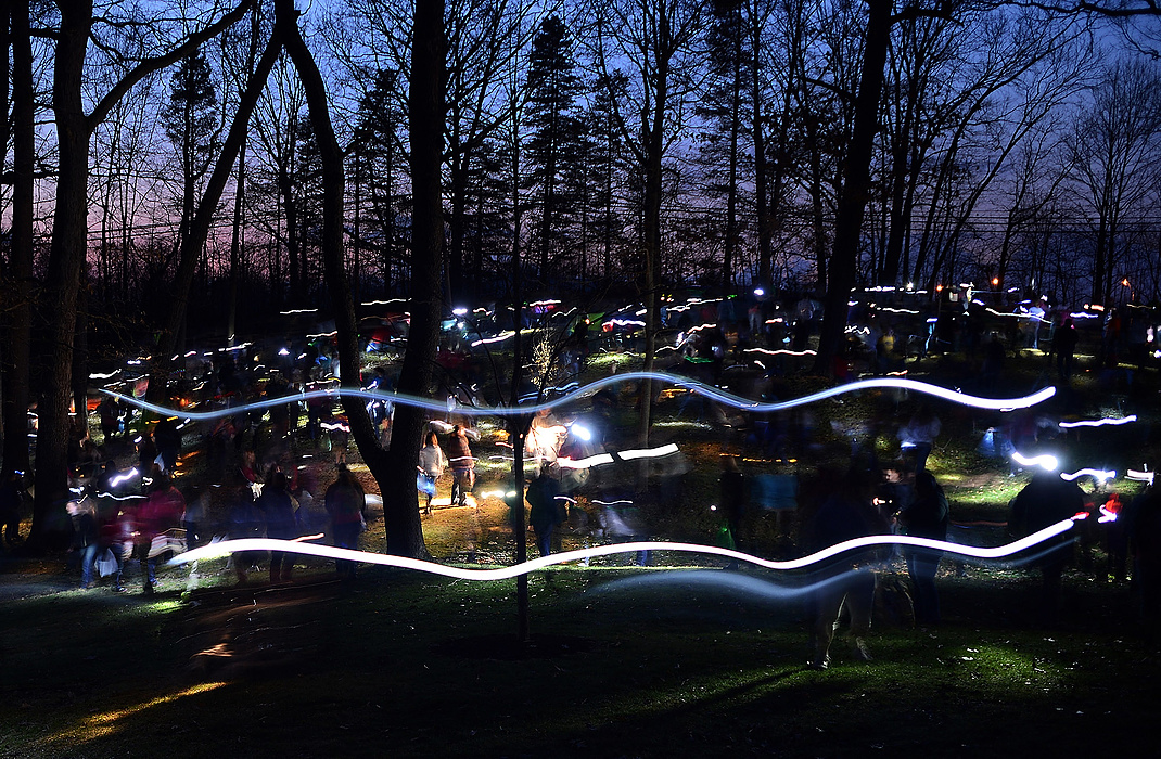 Third Place, Student Photographer of the year - Jenna Watson / Kent State University Participants in an adults-only Easter egg hunt at Fred Fuller Park in Kent use flashlights to scan the park's grass for eggs filled with raffle tickets. The tickets entered participants in a raffle containing pricey prizes, including two televisions, a bike, Xbox game system and more.