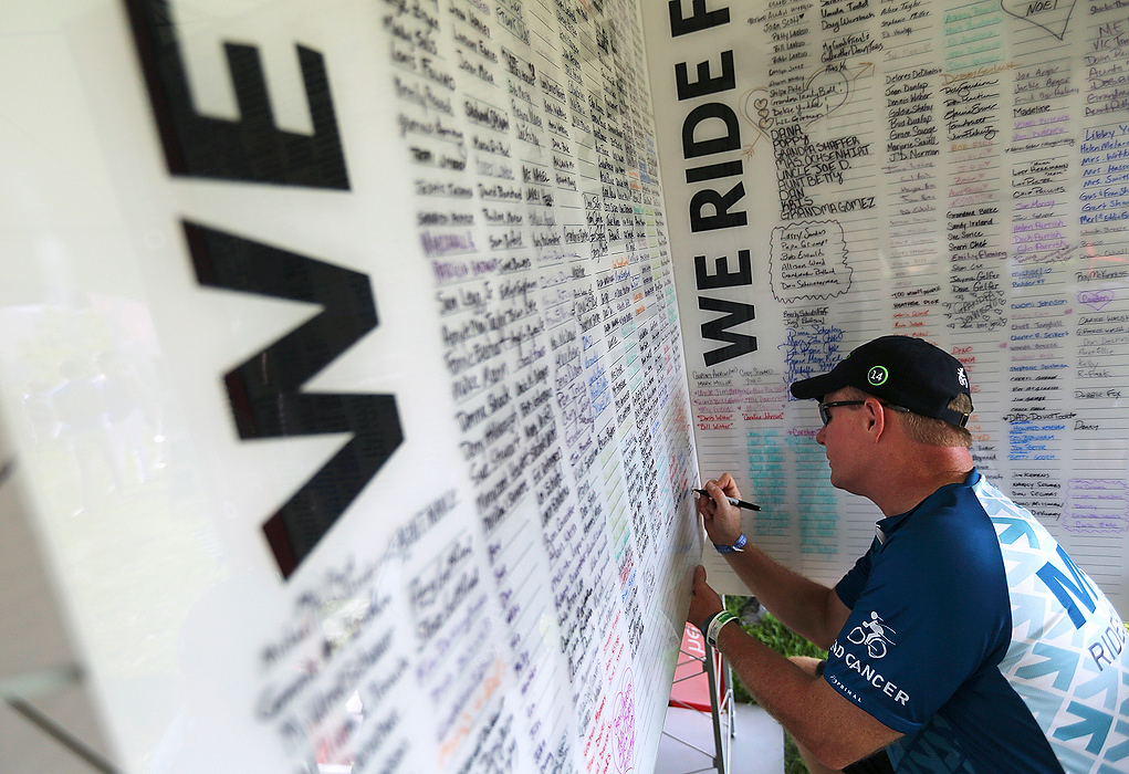 Third Place, Student Photographer of the year - Jenna Watson / Kent State University Rick Espe, of Columbus, signs the name of his wife who passed away from ovarian cancer, Morgen Espe, during the Pelotonia opening ceremonies in the Columbus Commons. Espe rode the 100-mile route with team MKSK. The wall in the James Cancer Clinic tent listed names of people whom bicyclists ride in dedication to. 