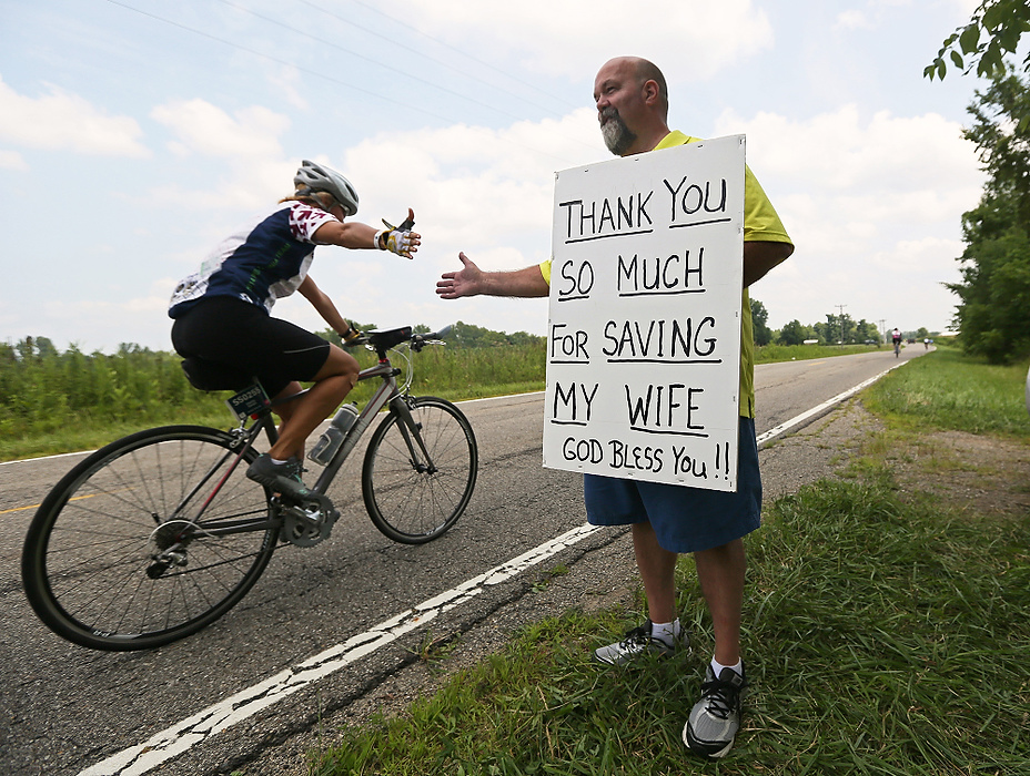 Third Place, Student Photographer of the year - Jenna Watson / Kent State University Chris Horton, of Mount Vernon, stands roughly at the eighty-fourth mile of the 100-mile Pelotonia ride, holding a sign that thanks bicyclists for contributing to the ability for his wife to receive life-saving chemotherapy, during Pelotonia on Homer Road, in Homer. Horton has made a memorable impression on riders, often evoking emotion and giving them inspiration to finish out the 100-mile ride. 