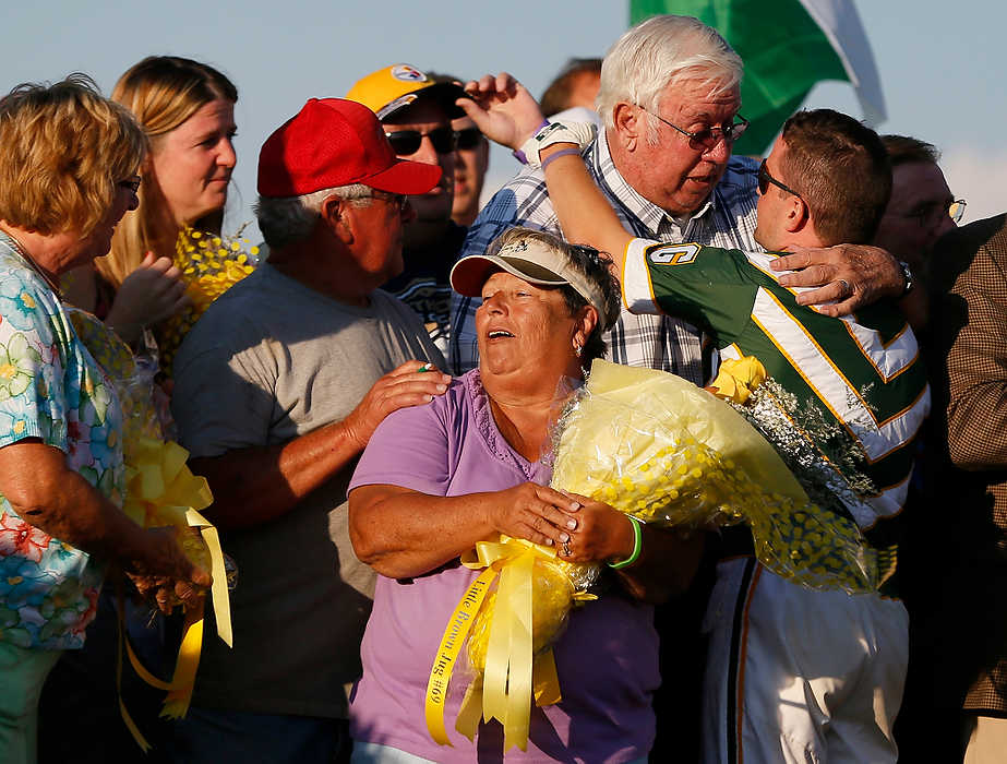 First Place, Sports Picture Story  - Eamon Queeney / The Columbus DispatchDriver Yannick Gingras (right) hugs Mickey Burke the father of the trainer Ron Burke and founder of the Burke racing family after the 69th running of the Little Brown Jug at the Delaware County Fairgrounds. Yannick Gingras driving Limelight Beach won the Little Brown Jug.