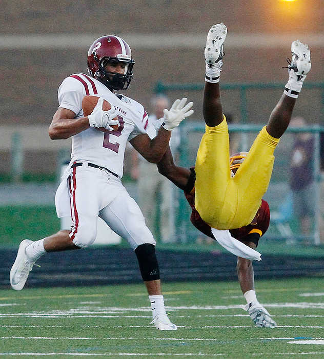 Second Place, Team Picture Story  - Chris Parker / ThisWeek Community NewsNewark's Darius Shackleford, left, comes down with the ball as Westerville North's Damani Johnson (right) falls to the ground.