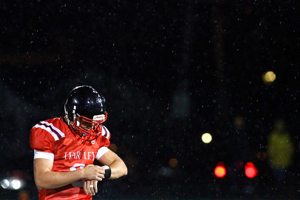 Second Place, Team Picture Story  - Ryan M.L. Young / ThisWeek Community NewsHartley quarterback Jake Ruby checks plays as rain falls down during their game against Bishop Watterson.