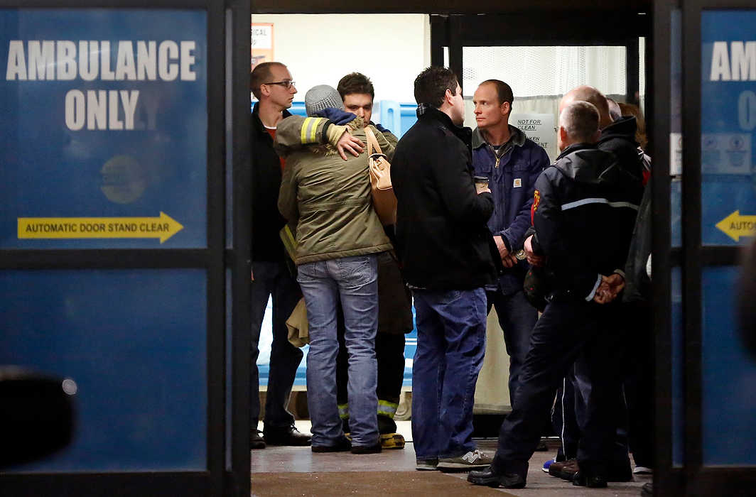 First Place, Team Picture Story  - Dave Zapotosky / The (Toledo) BladeToledo firefighters and others console each other at the hospital after two firefighters were killed while battling an apartment building fire. 