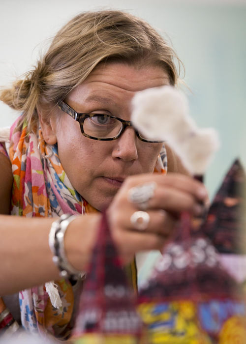 Second place, Larry Fullerton Photojournalism Scholarship - Alex Driehaus / Ohio UniversityWendy Minor Viny attaches a chimney to a fabric house sculpture at the Passion Works studio at Atco, Inc. in Athens.. Most of Viny's work at the studio centers around textiles.