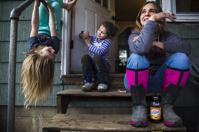 Second Place, Feature - Erin Clark / Ohio UniversityMary Jonas enjoys an evening on her stoop with granddaughter Emily (left) and friend Emma. The two sisters, along with the Jonas’ grandchildren, often spend weekends with Mary and her husband, Mike. The children enjoy the freedom and independence that the Jonas’ give them to explore around the farm and their ability to learn and be involved with the Jonas’ herd of over 50 boar goats. 