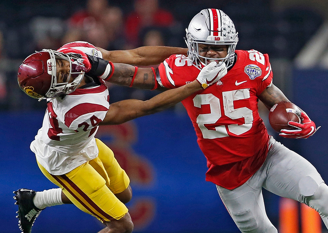 First Place, Sports Action - Kyle Robertson / The Columbus DispatchOhio State running back Mike Weber (25) gets a his face masked pulled by USC cornerback Isaiah Langley during the first half of the Cotton Bowl Classic at AT&T Stadium in Arlington, Texas. 