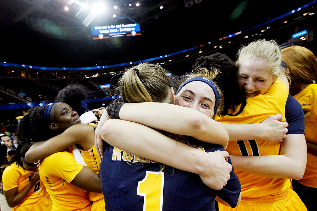 Award of Excellence, Sports Feature - Katie Rausch / The BladeToledo's Janice Monakana (left) is hugged by Kaayla McIntyre as Mariella Santucci (center) embraces by Sara Rokkanen (1) and Jay-Ann Bravo-Harriott (11) hugs Sophie Reecher (right) after they beat Northern Illinois to win the MAC Championship at the Quicken Loans Arena in Cleveland. Toledo won, 82-71. 