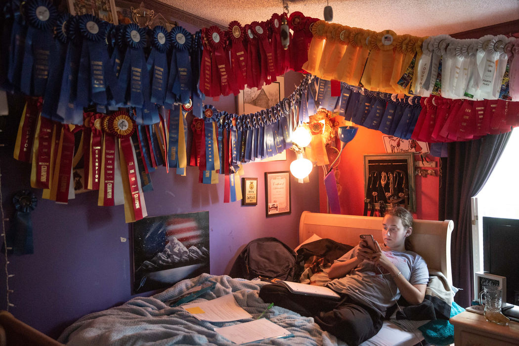 Second Place, Student Photographer of the Year - Liz Moughon / Ohio UniversityVictoria Epstien, 17, sits underneath a canopy of horse racing prizes in Liberty, N.Y. She takes a break from homework while recovering from Crypto that she got while tending a sick calf. Once she graduates, she hopes to join a collegiate equestrian team.