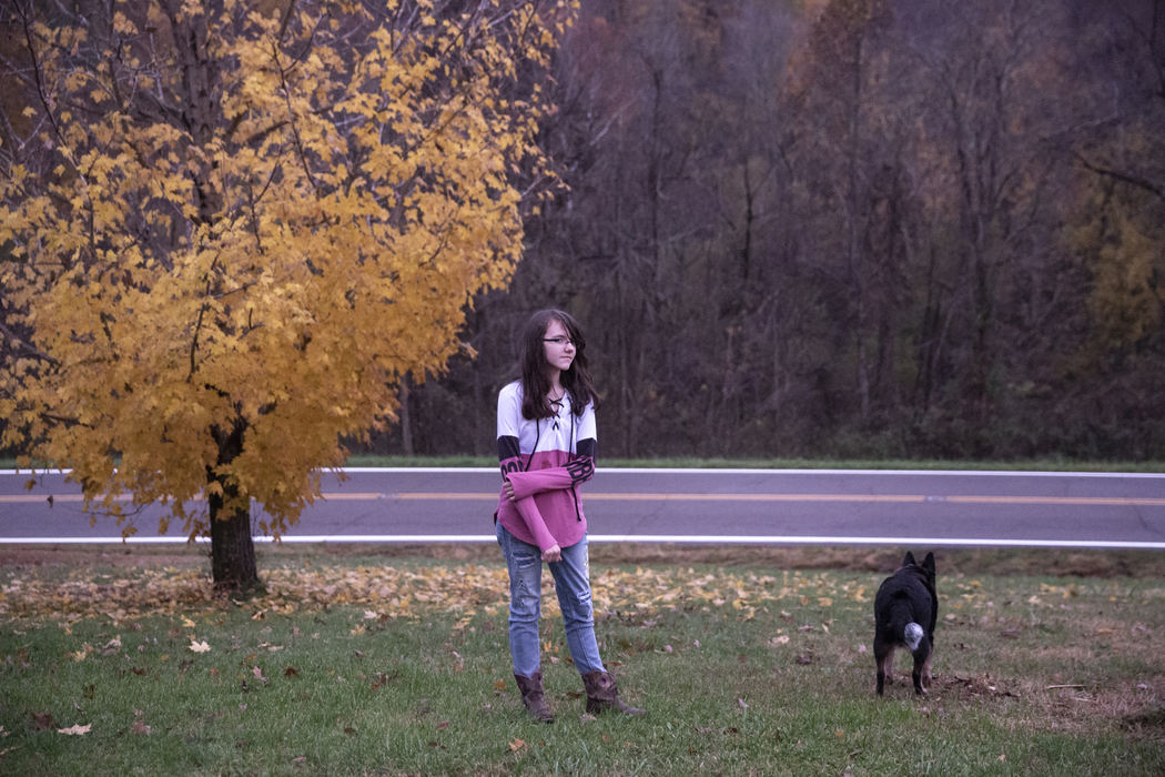 Second Place, Student Photographer of the Year - Liz Moughon / Ohio UniversityLibby Hall, 13, stands in her front yard with the family dog on a fading autumn day. The little bit of internet they get is barely enough for her father to work from home, so she often rides 20 minutes into town with her mother to finish her homework.