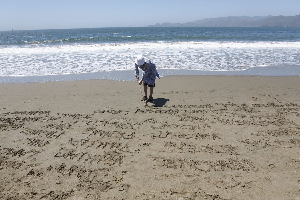Second Place, Student Photographer of the Year - Liz Moughon / Ohio UniversityErika Brooks, who lost her adopted daughter to a Golden Gate Bridge suicide, writes names of other suicide victims at Baker Beach. Throughout the day, families and friends take turns writing every recorded name of a bridge suicide victim - around 2,000 - in the sand and watch the waves wash them away. 