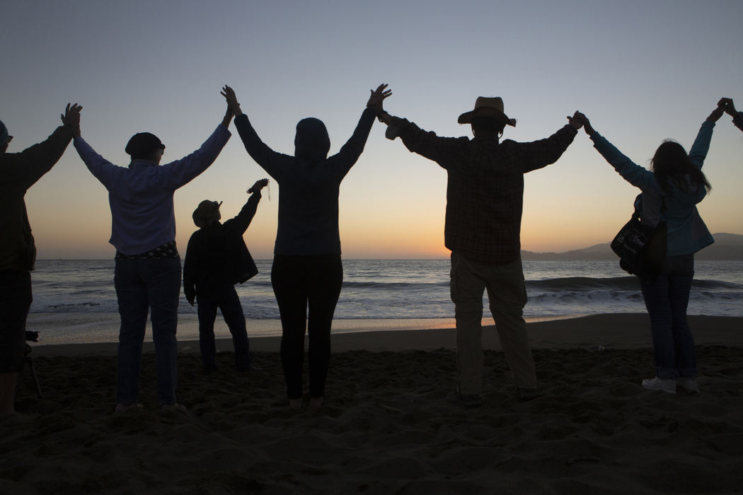Second Place, Student Photographer of the Year - Liz Moughon / Ohio UniversityKathy Contway, far right, Kyle's grandmother, holds hands with survivors as Dana Bark, third from left, burns sage at Baker Beach. Dana lost his son Donavan Bark to a Golden Gate Bridge suicide in 2008 and started "Names in the Sand."