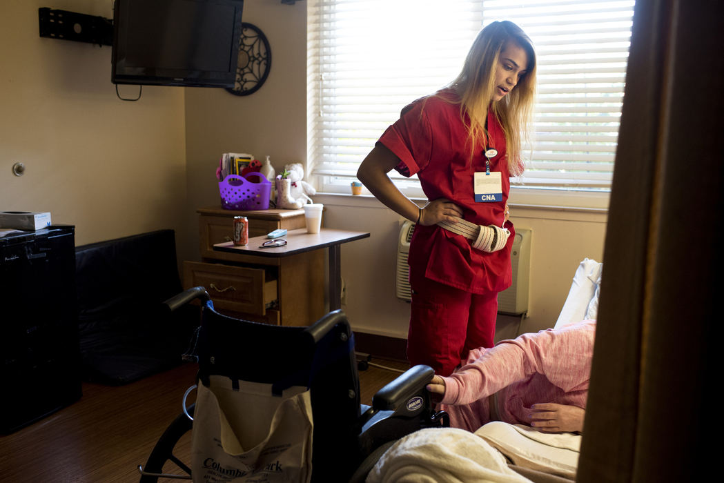 Third Place, Student Photographer of the Year - Marlena Sloss / Ohio UniversityAt North Park Nursing Center, Brooke uses a stern voice with a resident to help her transition from the bed to the wheelchair in Evansville, Ind. on Oct. 19, 2017. Eventually Brooke needed the help of two other staff members. As a certified nursing assistant (CNA), Brooke cares for adults by doing everything from delivering meals to changing their clothes and helping them shower. Between raising Vincent and her job as a CNA, she spends much of her time caring for others. 