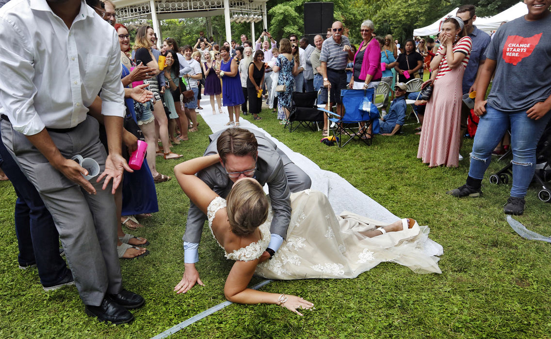 First Place, Feature - Eric Albrecht / The Columbus Dispatch, "Festival Wedding"Timothy Wolf Star kisses his bride Melissa Starr after he tripped carrying Melissa through the crowd after exchanging wedding vows on the gazebo at Comfest.Timothy has been coming to Comfest for 33 years and with Melissa for 3 and they wanted to share their wedding with the community.