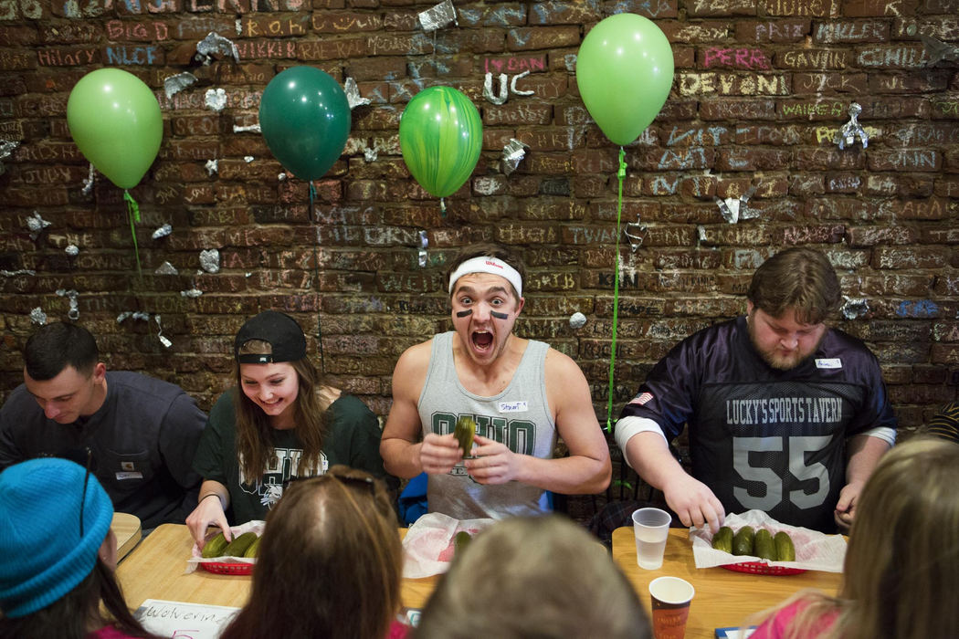 Second Place, Larry Fullerton Photojournalism Scholarship - Madeleine Hordinski / Ohio UniversityStuart "Pickle Rick" Brenkus (center) screams while competing in Bagel Street Deli's Pickle Fest in Athens on March 23, 2018. Brenkus, who took two pills of Tums antacid during the race, finished second in heat three, devouring seven pickles.