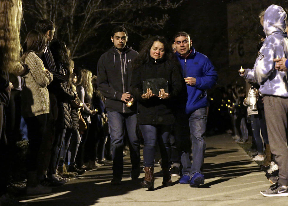 Third Place, General News - Shane Flanigan / ThisWeek Newspapers, "Student Vigil"Evelia Morales holds on tightly to the remains of her son, Andrew Morales, as she and her husband, Fernando Morales, right, and son, Luis Morales, make their way past rows of Dublin Coffman students and faculty after a vigil held in Andrew's honor March 8, at Dublin Coffman High School. Andrew died unexpectedly during a symphonic band practice on March 5.