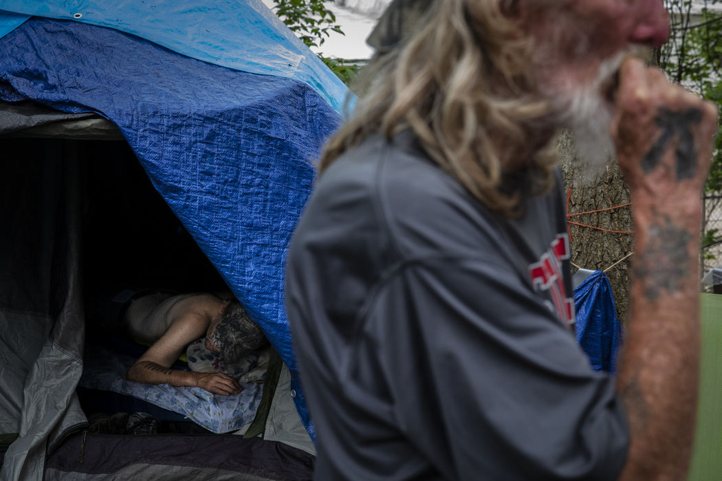 Second Place, News Picture Story - Nathaniel Bailey / Kent State University, "Tent City"Kevin, who is legally blind and suffers from seizures, sleeps in his tent, while Willie stands outside talking to other residents. Both have been residents of tent city for over six months, though neither make any attempts to find permanent housing.