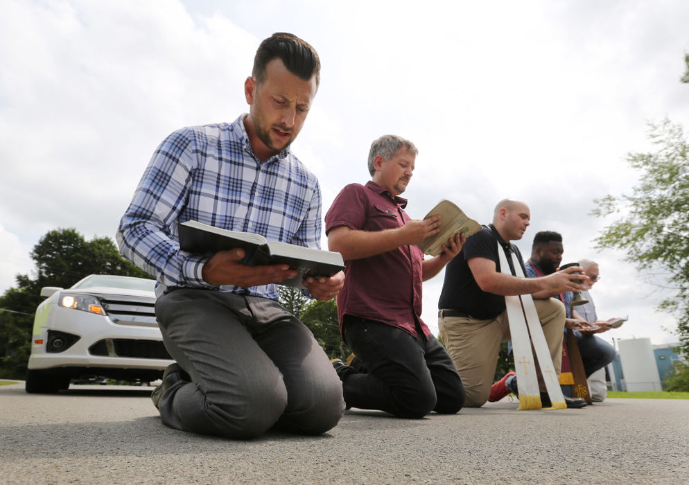 Third Place, News Picture Story - Gus Chan / The Plain Dealer, "Clergy Arrested"Clergymen block the driveway of the Northeast Ohio Correctional Center during a show of civil disobedience.  More than 50 members of Radial Church, Inter-religious Task Force on Central America and Colombia, America’s Voice Ohio, and allies stood in support of about 300 immigrants detained at the Northeast Ohio Correctional Center, a for-profit prison owned by CoreCivic. August 20, 2018 