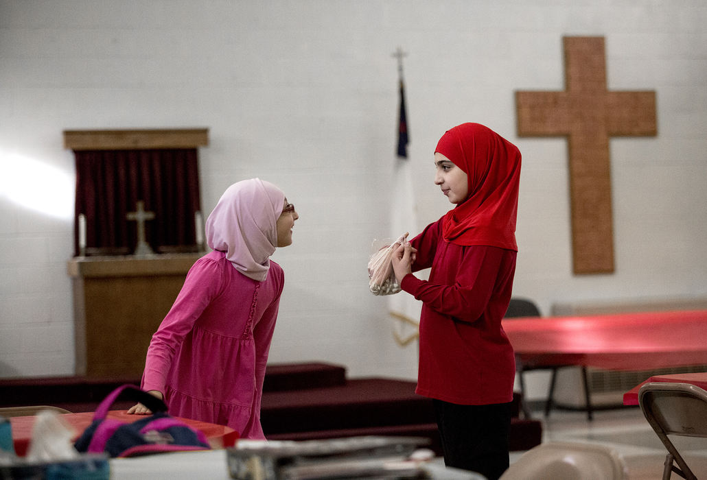 Second Place, Ohio Understanding Award - Jessica Phelps / Newark Advocate, "First Generation"Dima Al Haek (right) shares pistachios and gossips with her best friend Ghadja before the after school program they attend at St. James Lutheran Church begins, February 5, 2017. Dima's father, Ahmed, started the program so refugee and immigrant children could get help with homework. There are also English and citizenship classes for the adults.