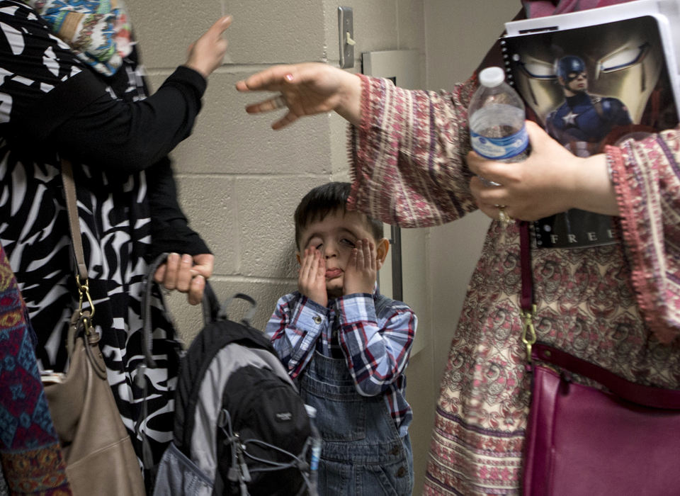 Second Place, Ohio Understanding Award - Jessica Phelps / Newark Advocate, "First Generation"Mousa Al Haek groans as he waits for his mom, Dunya, to finish saying her goodbyes at the St. James Lutheran Church, February 6, 2017. Ahmed Al Haek runs an after school program for refugees out the church to help them with homework. Adults can also take English classes and citizenship classes. 