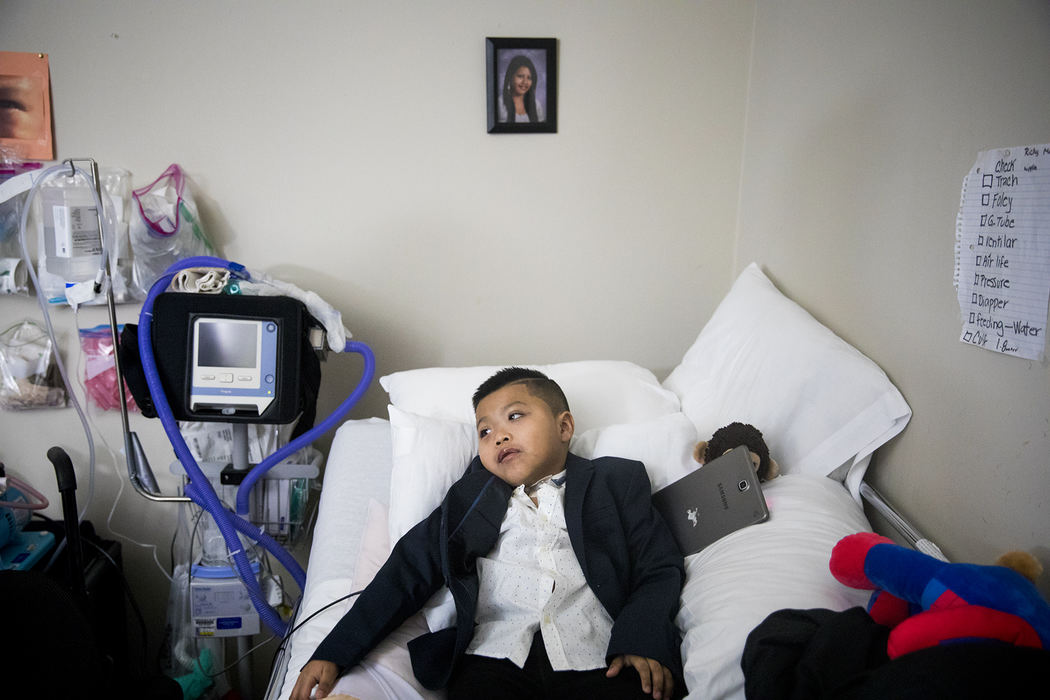 First Place, Photographer of the Year - Large Market - Meg Vogel / The Cincinnati EnquirerRicky Solis, 6, lays in bed after his mom and nurse dressed him in a blazer and button down shirt for his mom's wedding February 8, 2018. After an auto crash in February 2017, Ricky suffered severe injuries, including paraplegia and brain trauma. His mother's fiancé, Yancarlos Mendez, helped as a caretaker before he was detained by ICE in December 2017. 