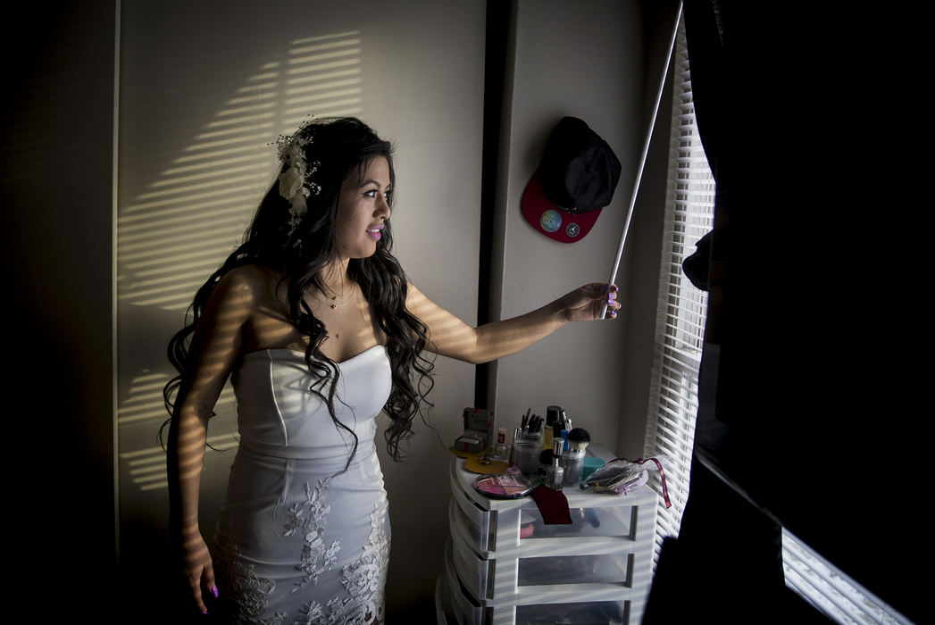 First Place, Photographer of the Year - Large Market - Meg Vogel / The Cincinnati EnquirerSandra Mendoza opens the blinds in her Springdale home Thursday, Feb. 8, 2018, as she waits for Pastor Alfredo Ortiz to pick her and her son, Ricky, up to drive more than two hours to Morrow County Jail in Mount Gilead, Ohio for her wedding.