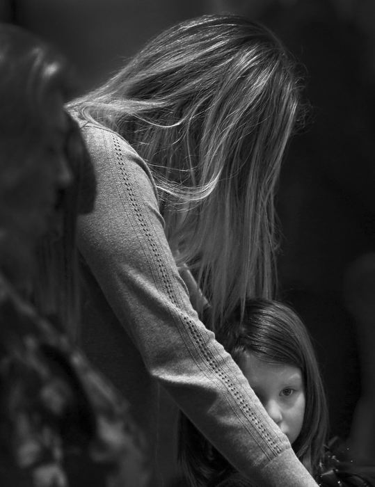 Second Place, Photographer of the Year - Large Market - Kyle Robertson / The Columbus DispatchWesterville officer Eric Joering’s wife, Jamie, puts her head down while her daughter, Ella, looks on during funeral services at St. Paul Catholic Church in Westerville on February 16, 2018.