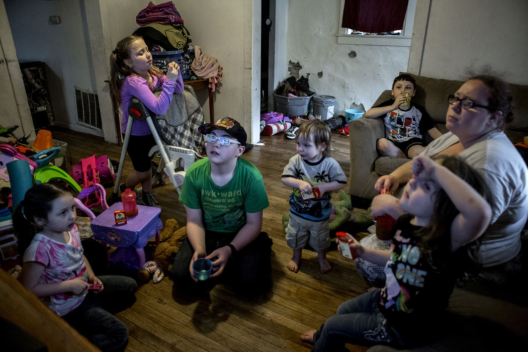 First Place, Photographer of the Year - Small Market - Jessica Phelps / Newark AdvocateMelissa Crawford (far right) sits on the couch and watches the weather report with her six children, Raquel, Layla, Jay, Tristan, Landon and Sorai to make sure their home was not in the path of a possible tornado, April 26, 2018 Their home is too small for the family, but it is the best Melissa and her fianc√©, Jack can afford. 