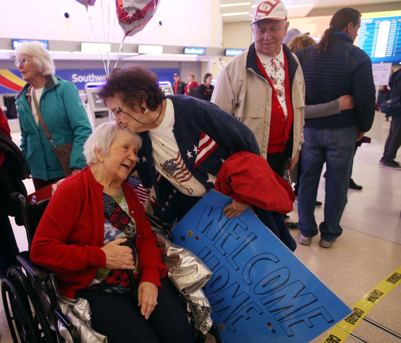 Second Place, Photographer of the Year - Small Market - Lorrie Cecil / ThisWeek NewspapersFriendship Village of Dublin resident Carole Pehoushek receives a kiss from fellow resident Connie Williams as Connie's husband Sam looks on.  They were at John Glenn International Airport on Saturday April 7 to welcome home veterans, including four from Friendship Village as they returned home from their  trip to Washington D.C. as part of Honor Flight Columbus.  Carole's husband Joe Pehoushek was one of the returning veterans.    