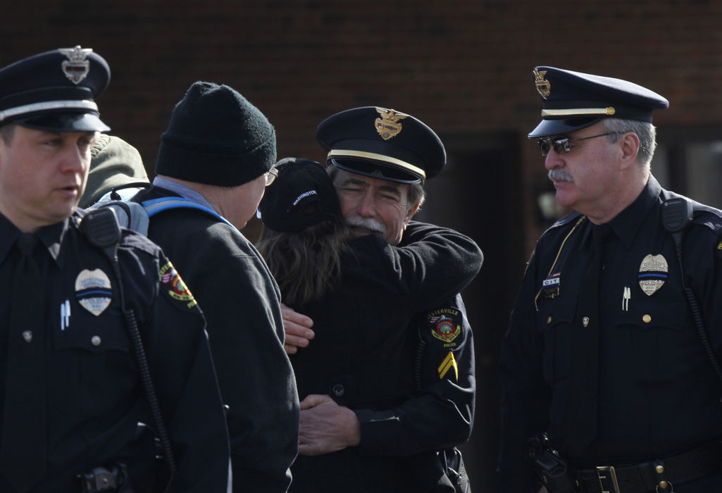 Second Place, Photographer of the Year - Small Market - Lorrie Cecil / ThisWeek NewspapersWesterville Division of Police officers Det. Steve Grubbs (far left), Cpl. Jack Johnson (center) and Sgt. Anthony Rudd (right) are consoled as they leave Moreland Funeral Home where the body of Westerville Division of Police officer Anthony Morelli was taken from the Franklin County Coronerís Office. A procession, which included officers from around the state, then escorted the body of officer Eric Joering to Hill Funeral Home.