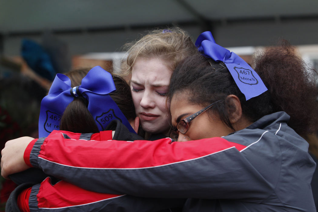 Second Place, Photographer of the Year - Small Market - Lorrie Cecil / ThisWeek NewspapersCenterburg Cheerleaders left to right Mikaila Griffith, Hope Lejeune and Korinne Newman console one another while at the memorial in front of Westerville City Hall for Officers Eric Joering and Anthony Morelli on Friday February 16.   The Centerburg cheerleading squad came and stood in front of City Hall holding a "Thin Blue Line" flag as the procession carrying the bodies of officers Joering and Morelli from the funeral homes to  St. Paul the Apostle Parish.  
