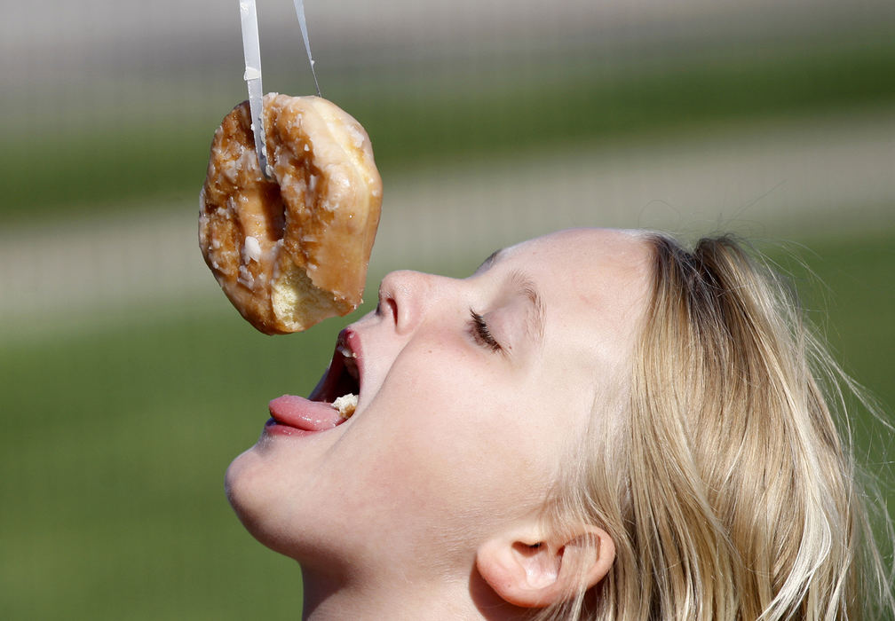 , Photographer of the Year - Small Market - Shane Flanigan / ThisWeek NewspapersLita Jenkins, 9, of Westerville, determinedly takes bites from a suspended doughnut without using her hands at Otterbein University Center for Community Engagement's annual Fall Harvest Festival on Sept. 29, 2018, at the Otterbein Community Garden in Westerville, Ohio.