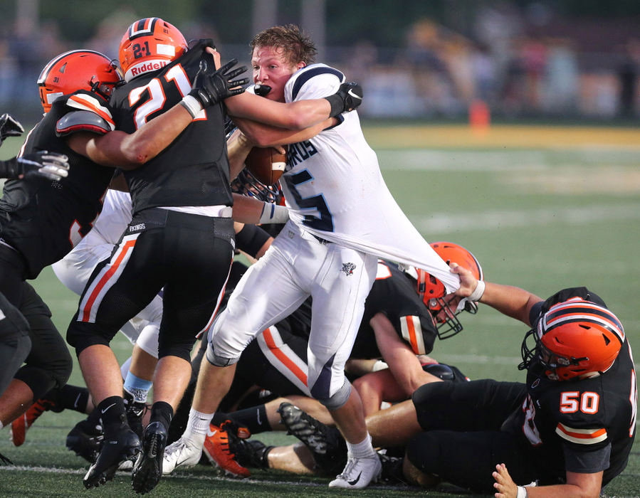 Award of Excellence, Photographer of the Year - Small Market - Scott Heckel / The Canton RepositoryLouisville's Max Hartline (5) is brought down by Hoover's Elliot Tornow (21) and Chase Columber (50) on fourth down during the second quarter of their game at Hoover on Friday, August 31, 2018.