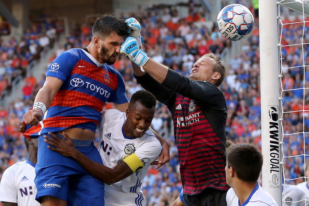 First Place, Sports Action - Kareem Elgazzar / The Cincinnati Enquirer, "Punched"FC Cincinnati defender Forrest Lasso (3) is punched in the face by Charlotte Independence goalkeeper Andrew Dykstra (50) on an attempt on goal in the first half of a USL match, July 18, 2018, at Nippert Stadium in Cincinnati. 