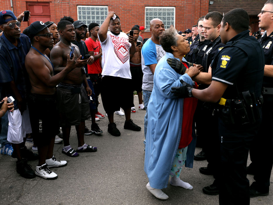 First Place, Spot News - Kurt Steiss / The Blade, "Shooting"Alfreada Radford Tucker, grandmother of Lamar Richardson, is distraught as she approaches the police line as people gather near the scene of an officer-involved shooting near LaGrange and Hudson streets in Toledo on July 27, 2018. Richardson, the 25-year-old man who was shot and killed by police, was described by Toledo Police as a “person of interest” in multiple robberies. Police fired at him after he “produced a weapon.”